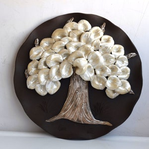 May include: A white ceramic tree sculpture with a brown background. The tree has many leaves and a textured trunk.