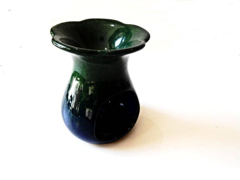 May include: A green and blue ceramic oil burner with a scalloped rim. The burner has a small opening in the centre for a tea light.