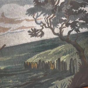 May include: A framed tapestry showing a coastal scene with a sailboat, a tree, and a shoreline. The artwork uses brown, green, and blue hues to create a tranquil landscape.