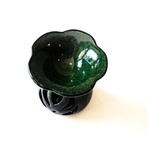 May include: A green ceramic oil burner with a flower-shaped top and a decorative, openwork base.