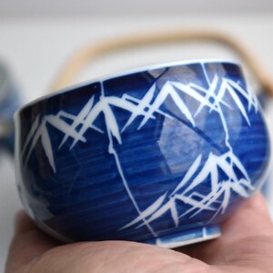 Puede incluir: Una taza de t&eacute; de cer&aacute;mica azul y blanca con un dise&ntilde;o de bamb&uacute;. La taza tiene un asa y est&aacute; hecha de porcelana.