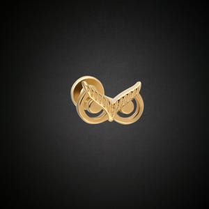 May include: Gold owl-shaped earring with a textured design.
