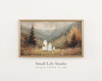 May include: A rectangular landscape painting in a gold frame depicting three white ghost figures standing in a grassy field with pine trees and mountains in the background. The largest ghost holds a small orange pumpkin. Text reads Small Lily Studio.
