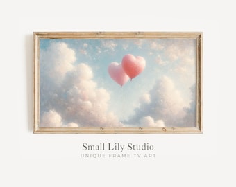 May include: A framed print depicting two pink heart-shaped balloons against a backdrop of a cloudy sky. The artwork uses a soft, pastel colour palette with a light blue sky and fluffy white clouds. The frame is a light brown colour.
