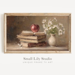 May include: A framed still life painting featuring a stack of books, a red apple, and a white vase of flowers. The artwork has a vintage aesthetic with a warm color palette. The text "Small Lily Studio UNIQUE FRAME TV ART" is at the bottom.