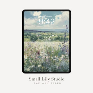 Puede incluir: Un iPad muestra un fondo de pantalla digital con una pintura de paisaje serena. La obra de arte presenta un campo de flores silvestres bajo un cielo nublado, con la hora y la fecha en la parte superior. El texto "Small Lily Studio" y "IPAD WALLPAPER" están en la parte inferior.