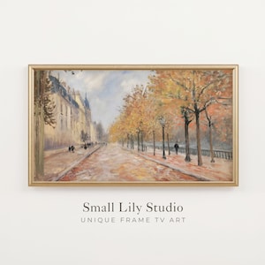 May include: A rectangular landscape painting in a thin gold frame depicting a Parisian street scene in autumn with golden trees, a stone building, and figures walking along a path. Below the frame, the text reads Small Lily Studio UNIQUE FRAME TV ART.