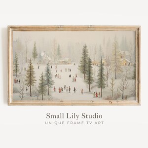 May include: A framed vintage winter scene print. The artwork shows a snowy landscape with people ice skating on a frozen pond, surrounded by trees and buildings. The frame is a light brown colour.