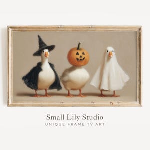 以下が含まれることがあります： ハロウィーンの衣装を着た3羽のガチョウが描かれた額入りのプリント。1羽は魔女の帽子とマント、もう1羽は彫刻されたカボチャの頭、3羽目は幽霊のコスチュームを着ています。アートワークはヴィンテージスタイルです。