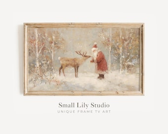 May include: A framed vintage-style painting depicts Santa Claus in a red coat and hat, interacting with a reindeer in a snowy forest. The artwork has a muted color palette with a light brown wooden frame. The text "Small Lily Studio" is at the bottom.