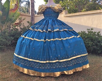 Könnte beinhalten: Ein blaues Ballkleid mit goldenen Verzierungen und Verzierungen. Das Kleid hat ein tailliertes Oberteil und einen vollen Rock. Der Rock ist mit Rüschen geschichtet und hat einen goldenen Saum am unteren Rand.