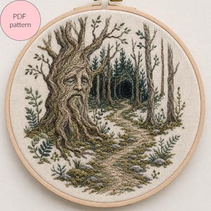 May include: An embroidery hoop containing a fabric panel with a detailed needlework scene of a forest path. A large, ancient tree with a human-like face in its trunk stands on the left, while a winding trail leads into a dark, dense woodland.
