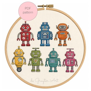 Könnte beinhalten: Ein Stickrahmen mit einem Kreuzstichmuster von sieben Robotern in verschiedenen Farben: rot, blau, orange, gelb, grün, türkis und rosa. Der Text "PDF pattern" befindet sich in einem rosa Kreis. Der Name des Künstlers steht unten.