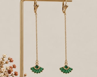 May include: A pair of gold-tone drop earrings featuring a long, delicate chain suspended from a lever-back closure. At the base of each chain is a fan-shaped pendant adorned with multiple baguette-cut green stones and a single round green stone.