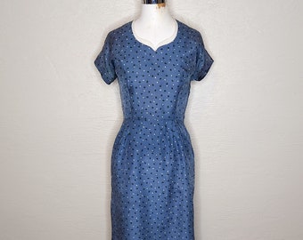 May include: A blue midi dress with a white collar and a white polka dot pattern.