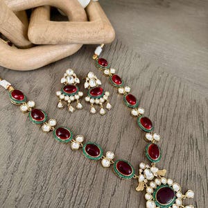 Puede incluir: Una taza de cerámica blanca con un asa negra y el texto "But First, Coffee" en negrita negra. La taza está llena de un líquido oscuro, probablemente café, y se encuentra sobre una superficie de color claro.