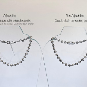 May include: Two silver ball chain necklaces on display stands. The necklace on the left has a lobster clasp with an extension chain. The necklace on the right has a classic chain connector that snaps on.