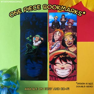 May include: Two One Piece bookmarks featuring character illustrations. One bookmark has a sleeping character, the other has a group of characters. The text "ONE PIECE BOOKMARKS" is at the top. The text "DESIGN IS NOT DOUBLE-SIDED" is at the bottom.
