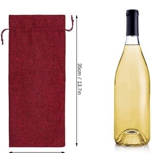 May include: A red burlap wine bottle bag with a drawstring closure. The bag measures 15 inches wide and 13.7 inches tall. The bag is suitable for a 750 ml wine bottle.