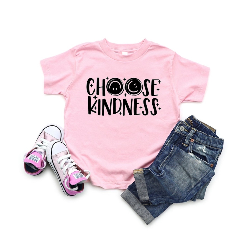 May include: Pink t-shirt with black text that says "Choose Kindness" with two smiley faces.