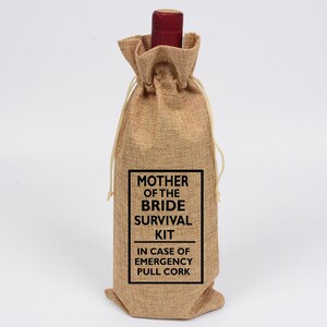 May include: A burlap wine bottle bag with a black label that reads "Mother of the Bride Survival Kit In Case of Emergency Pull Cork".