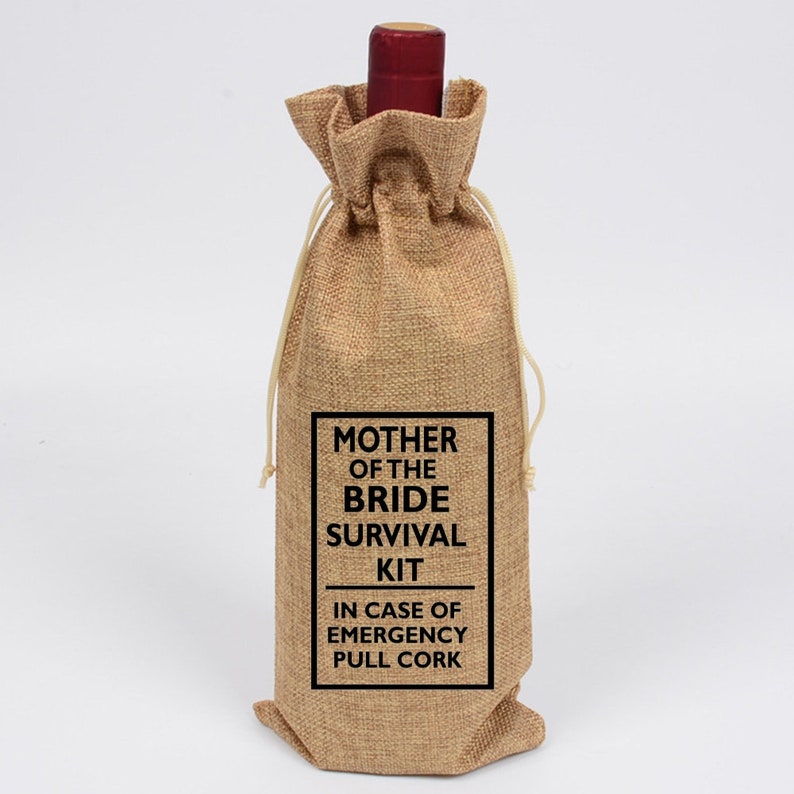 May include: A burlap wine bottle bag with a black label that reads "Mother of the Bride Survival Kit In Case of Emergency Pull Cork".