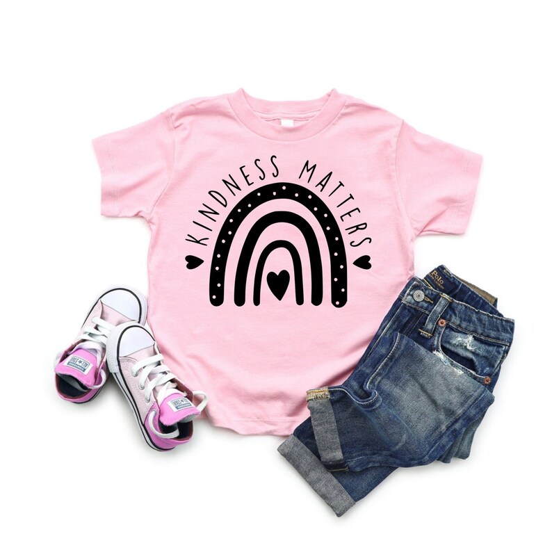 May include: Pink t-shirt with a black rainbow and the text "Kindness Matters".