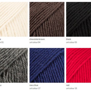 May include: Yarn samples in various colors, including off-white, chocolate brown, black, dark grey, navy blue, and red. The yarn is arranged in a grid pattern.
