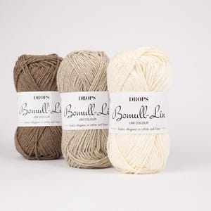 Può includere: Tre gomitoli di filato in marrone, beige e bianco. Il filato è etichettato "DROPS Bomull-Lin UNI COLOUR" e descrive il filato come "eleganza rustica in cotone e lino."