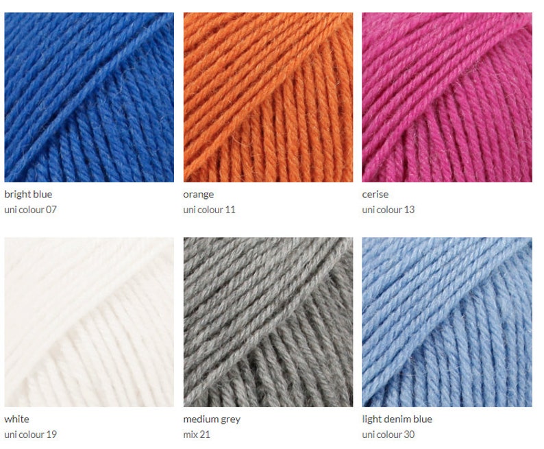 May include: Six skeins of yarn in different colors: bright blue, orange, cerise, white, medium grey, and light denim blue. The yarn is arranged in two rows of three skeins each.