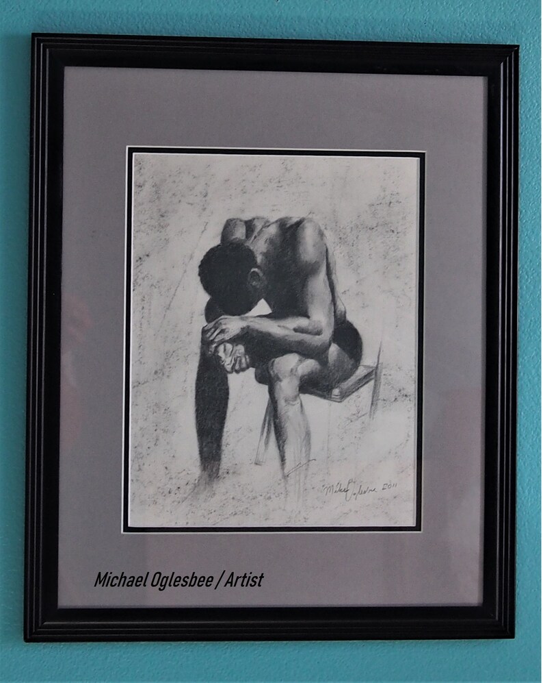 Puede incluir: Un dibujo en blanco y negro de una persona sentada con la cabeza gacha, enmarcado en un marco negro con un paspart&uacute; gris. La firma del artista es visible en la esquina inferior derecha del dibujo. El texto "Michael Oglesbee / Artist" est&aacute; impreso debajo del dibujo.