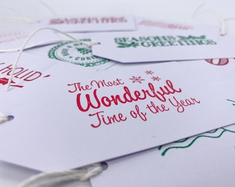 May include: White gift tags with red and green ink. The tags have different holiday greetings, including "The Most Wonderful Time of the Year".