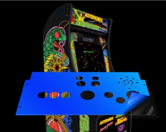 May include: A blue control panel with multiple round holes for buttons and a single hole for a joystick. The panel is being peeled back to reveal a black surface underneath.