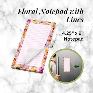 Op de afbeelding: Bloemennotitieblok met lijnen. Het notitieblok is 10,8 cm x 22,9 cm groot en heeft een bloemenrand met roze en paarse bloemen. De gelinieerde pagina's zijn roze. De tekst "Floral Notepad with Lines" staat bovenaan.