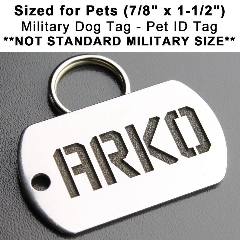 K&ouml;nnte beinhalten: Ein silberfarbener Hundemarkenanh&auml;nger aus Metall mit abgerundeter rechteckiger Form und einem daran befestigten Ring. Die Marke ist mit dem Text "&bull;ARKO" in einer fetten, klobigen Schrift graviert. Die Marke ist f&uuml;r Haustiere konzipiert und misst 7/8 Zoll mal 1 1/2 Zoll. **NOT STANDARD MILITARY SIZE**