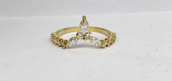 Curved wedding band with round and marquise diamonds in 14kt gold.