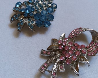 Set van twee damesbroches. Zilveren kristallen broches. Blauwe en roze broches