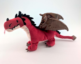 May include: A plush red dragon toy with black spines and brown wings. The dragon has a pink tongue and is standing on all fours. The wings have a metallic sheen.