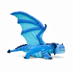 Könnte beinhalten: Ein blaues Plüschdrachen-Spielzeug mit großen Flügeln. Der Drache hat einen hellblauen Körper mit dunkelblauen Akzenten an Flügeln, Beinen und Rücken. Der Drache liegt auf einer weißen Oberfläche.