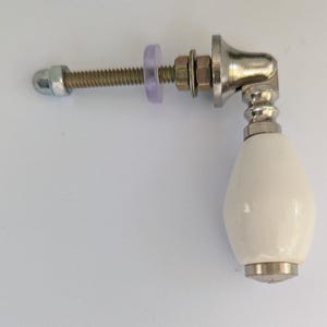 May include: White ceramic door knob with a silver metal base and a threaded metal rod with a nut and washer.
