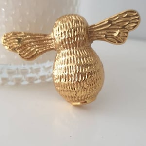 Può includere: Pomo per armadio a forma di ape dorata con superficie testurizzata.