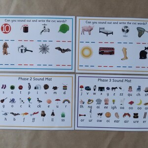 May include: Four educational cards for early learning. The top cards feature illustrations with the text "Can you sound out and write the cvc words?" The bottom cards are labeled "Phase 2 Sound Mat" and "Phase 3 Sound Mat."