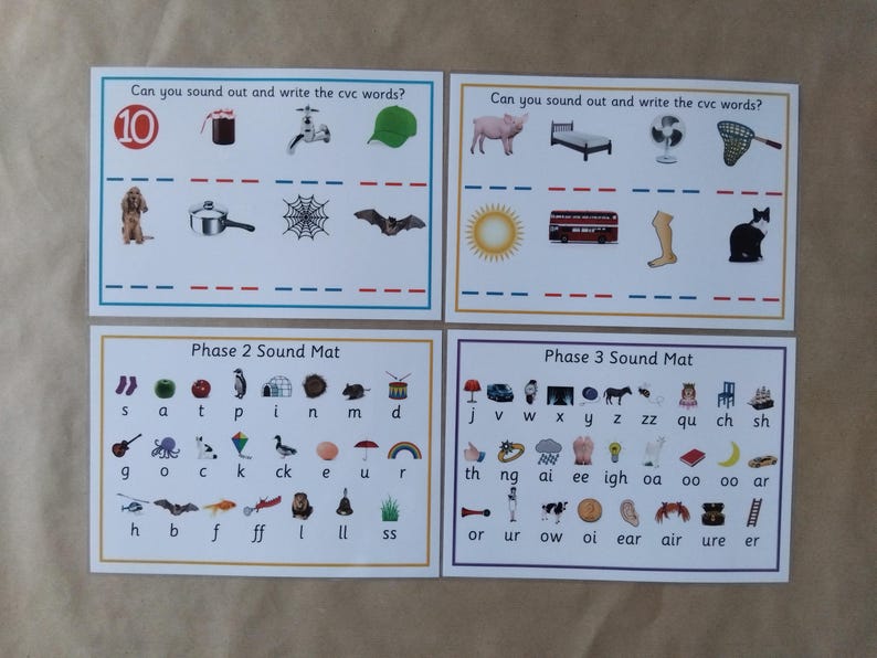 May include: Four educational cards for early learning. The top cards feature illustrations with the text "Can you sound out and write the cvc words?" The bottom cards are labeled "Phase 2 Sound Mat" and "Phase 3 Sound Mat."
