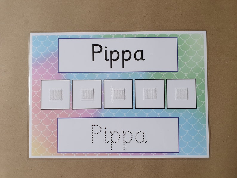 May include: A laminated educational chart with the name "Pippa" in large, bold letters at the top and bottom. The background features a pastel mermaid scale pattern. Five small squares with textured patches are in the center.