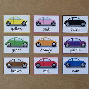 Może przedstawiać: Dziewięć kart z kolorowymi ilustracjami samochod&oacute;w. Każda karta przedstawia samoch&oacute;d w innym kolorze: ż&oacute;łtym, r&oacute;żowym, czarnym, zielonym, pomarańczowym, fioletowym, brązowym, czerwonym i niebieskim. Nazwa koloru jest wydrukowana pod każdym samochodem.