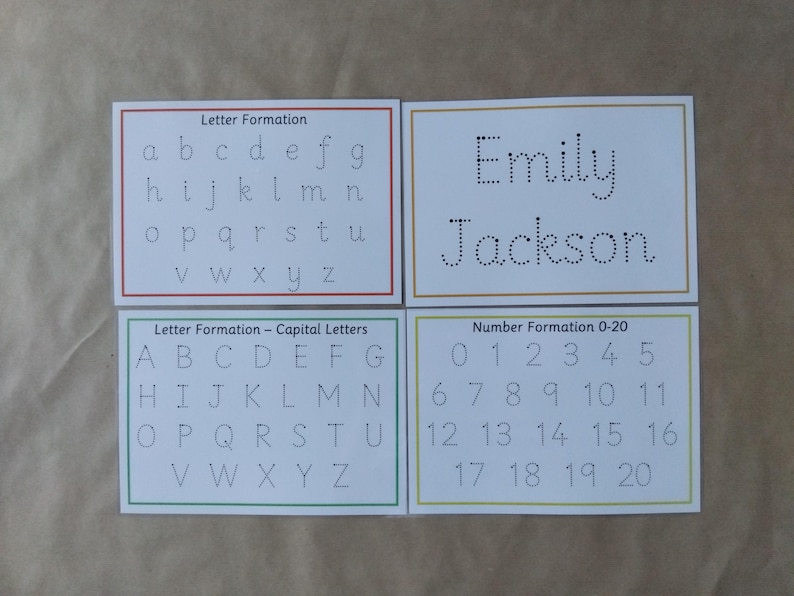 May include: Four white cards with educational content. One card shows lowercase letters for letter formation. Another displays the name "Emily Jackson" in dotted lines. The other two cards show capital letters and numbers 0-20.