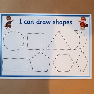 May include: White educational worksheet with blue border featuring the text "I can draw shapes" and illustrations of shapes. Includes a circle, square, triangle, and other shapes. Superhero illustrations are in the corners.