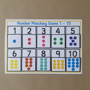May include: A number matching game titled "Number Matching Game 1-10". The game displays a grid of cards with numbers 1 to 10, each paired with a matching number of coloured dots. The dots are blue, red, pink, green, yellow, and teal.