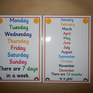 May include: Two educational posters with a white background and a red border. One poster lists the days of the week in colorful text, the other lists the months of the year. Each poster has a sun graphic and a rainbow graphic.