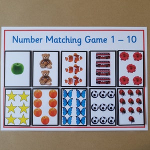 May include: A number matching game with the title "Number Matching Game 1-10". The game features cards with images of apples, teddy bears, clownfish, red buses, flowers, stars, oranges, butterflies, soccer balls, and ladybugs.